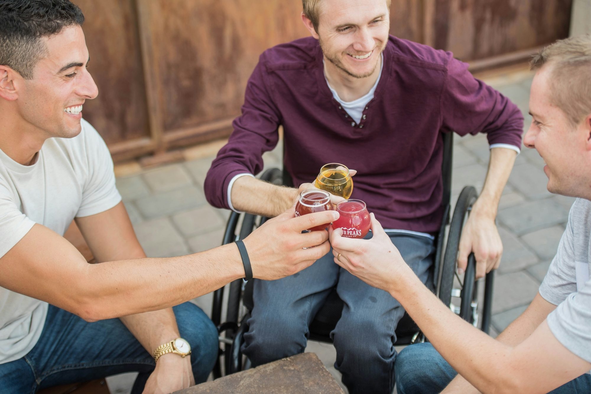 Une personne en fauteuil roulant prend un verre avec ses amis
